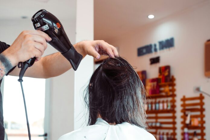 Photo by Nicolás Flor woman in white shirt holding hair blower